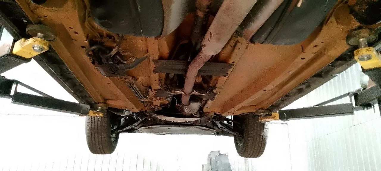 Вид снизу на обработанное днище автомобиля на подъёмнике